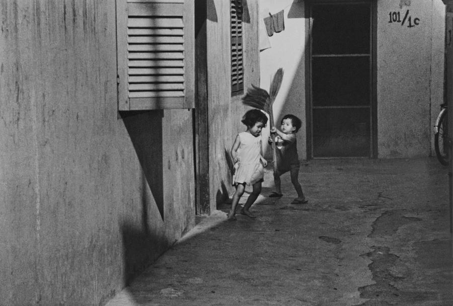 Vietnamese Boy and Girl playing Photograph by John Gilroy