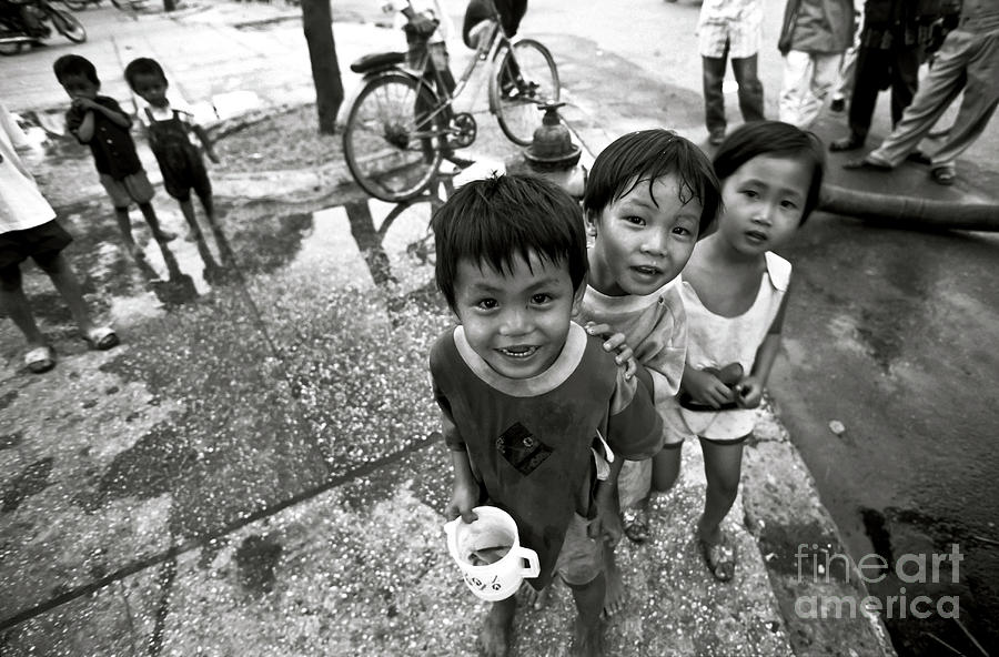 Vietnamese street children playing with a goldfish Photograph by Silva Wischeropp