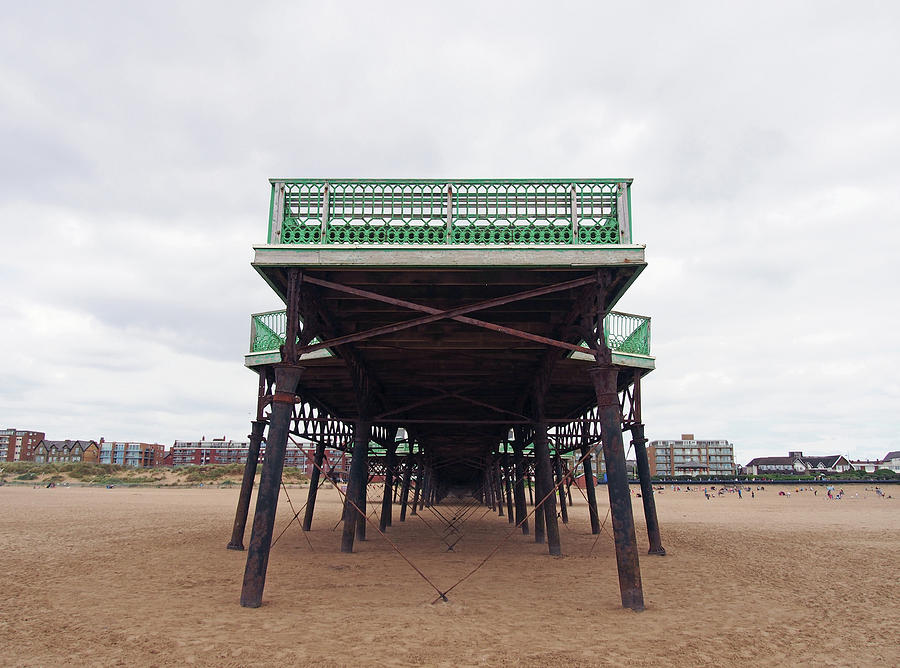 View Of The Historic Victorian Pier At Saint Annes On Sea In In Lancashire With The Beach At Low Tide And Buildings Along The Shore Photograph by Philip Openshaw