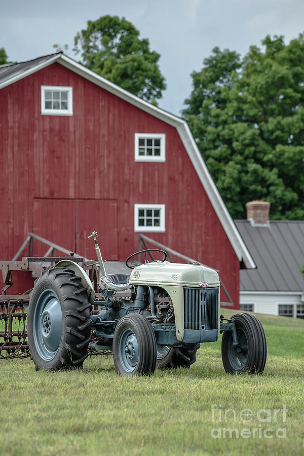 Vintage Ford farm tractor with red barn Photograph by Edward Fielding