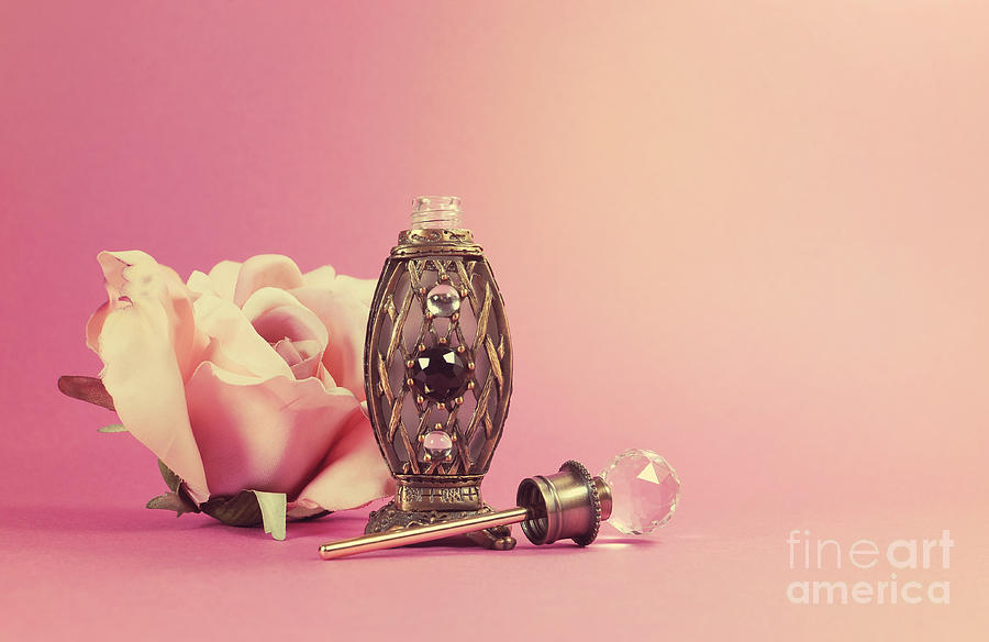 Vintage perfume bottle with crystal stopper and silk rose  Photograph by Milleflore Images