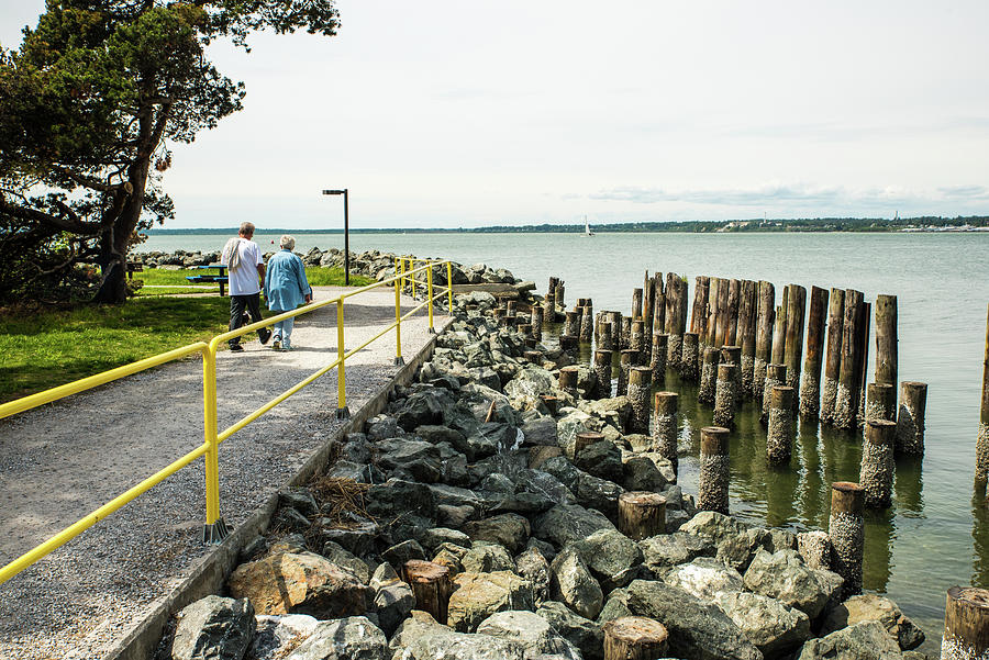 Walking by Rocks and Pilings Photograph by Tom Cochran