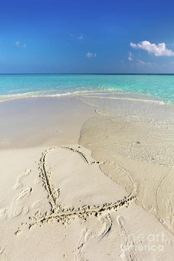 Waves wash away a heart drawn on sand of a tropical beach Photograph by Michal Bednarek