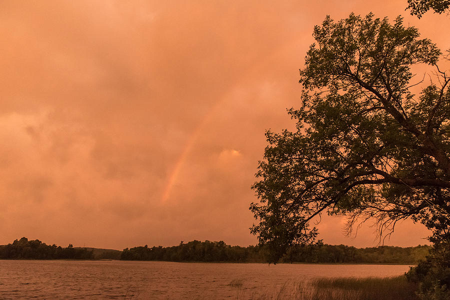 Strange orange sunrise with rainbow Photograph by Gary Eason