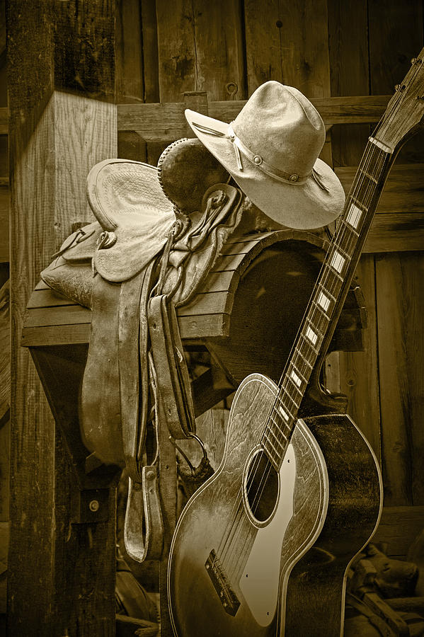 Western Country 6 String Acoustic Guitar in Sepia Tone with Horse Saddle Photograph by Randall Nyhof