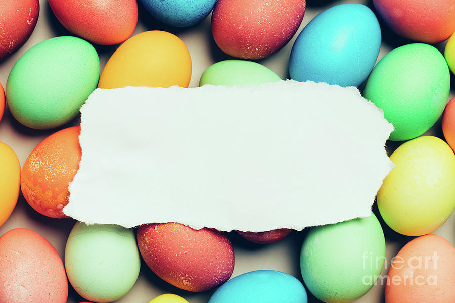 White paper laying on top of colorful eggs. Photograph by Michal Bednarek