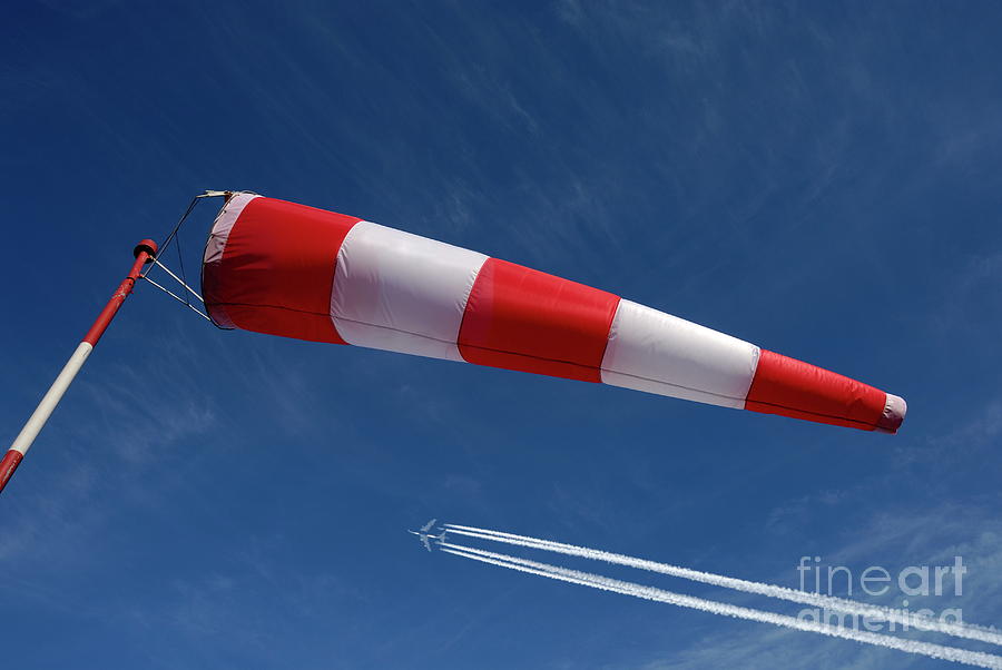 Windsock and airplane against sky Photograph by Sami Sarkis