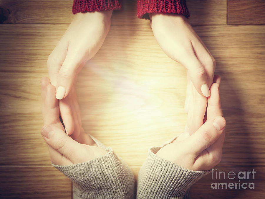 Magic Photograph - Woman and man making circle with hands. Warm light inside by Michal Bednarek