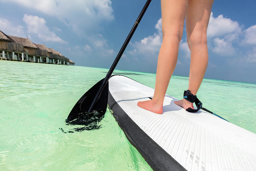 Woman does stand up paddle boarding on the ocean in Maldives Photograph by Michal Bednarek