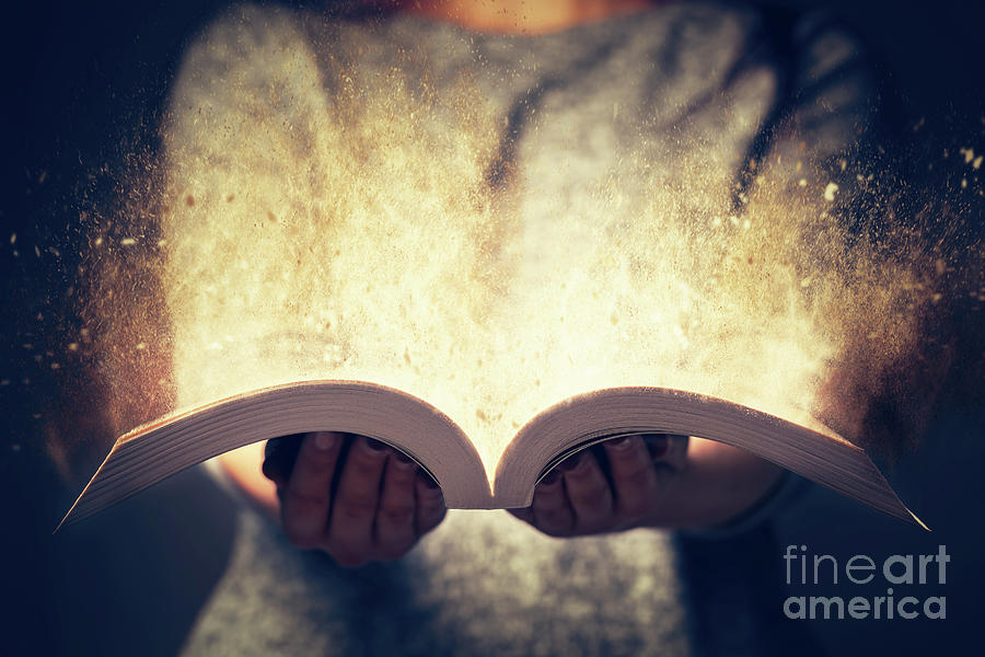 Woman holding an open book bursting with light. Photograph by Michal Bednarek