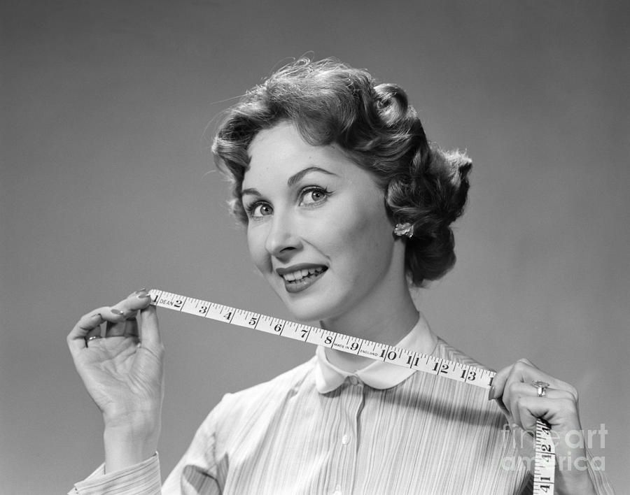 Portrait of a beautiful seamstress carrying a tape measure and