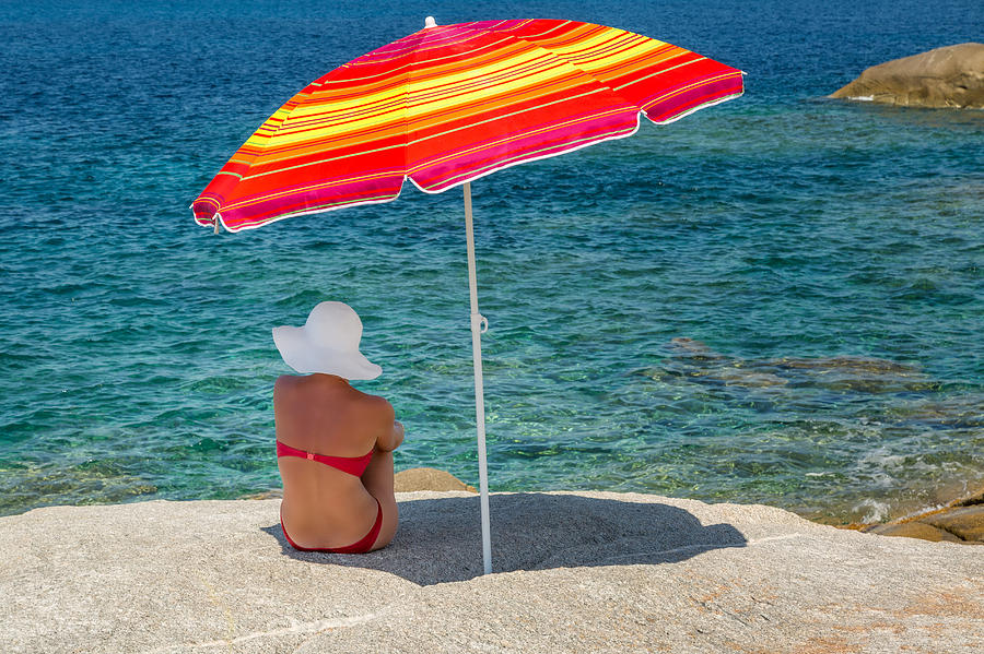Hat Photograph - Woman in red bikini and white hat under parasol looking out to s by Jon Ingall