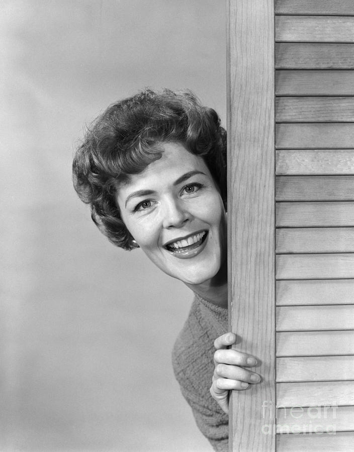 Woman Peeking Around Door, C.1960s Photograph by H. Armstrong Roberts/ClassicStock