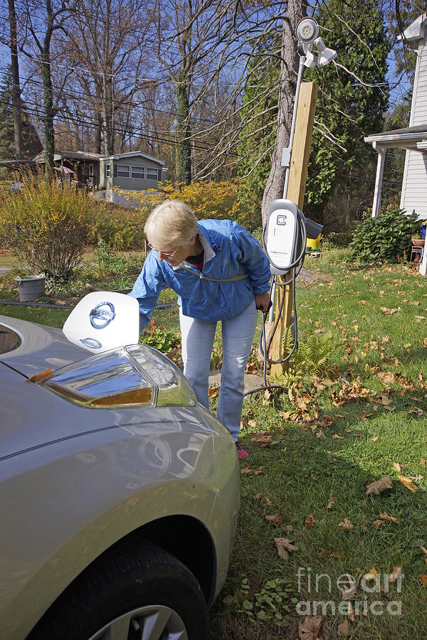 Woman Recharges Electric Car At Home Photograph by Blair Seitz