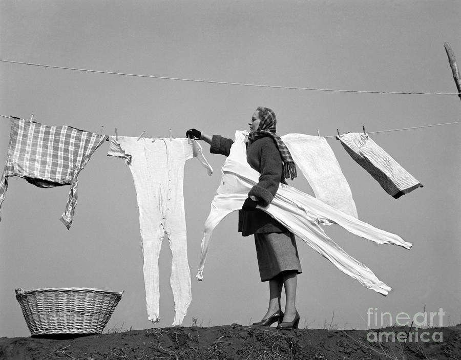 Woman Removing Frozen Clothes Photograph by Debrocke/ClassicStock