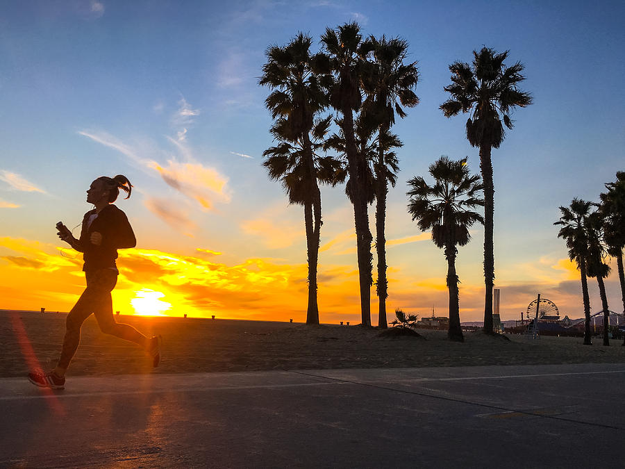 Woman running on Santa Monica Beach, California, USA Photograph by Anna ...