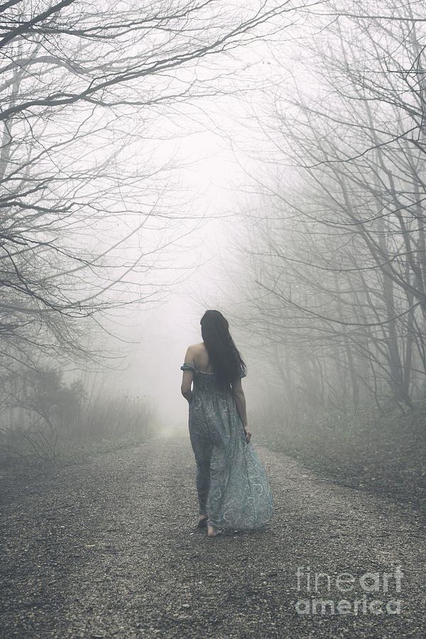 Woman walking along foggy path Photograph by Clayton Bastiani