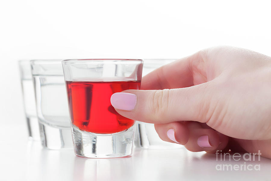 Womans hand reaching for a glass of alcohol drink Photograph by Michal Bednarek