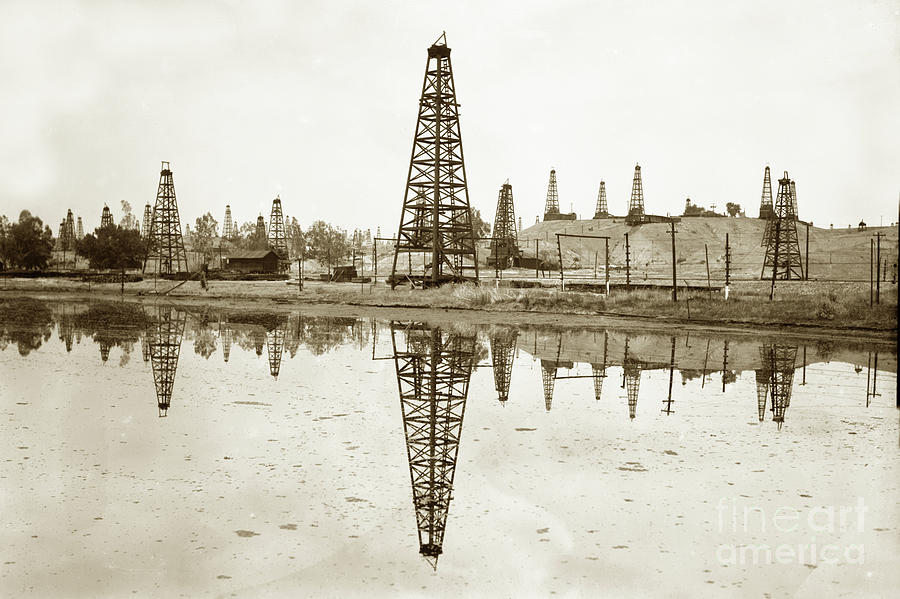 California Photograph - wooden derrick reflection in  oil kak  California Oil Field circ by Monterey County Historical Society