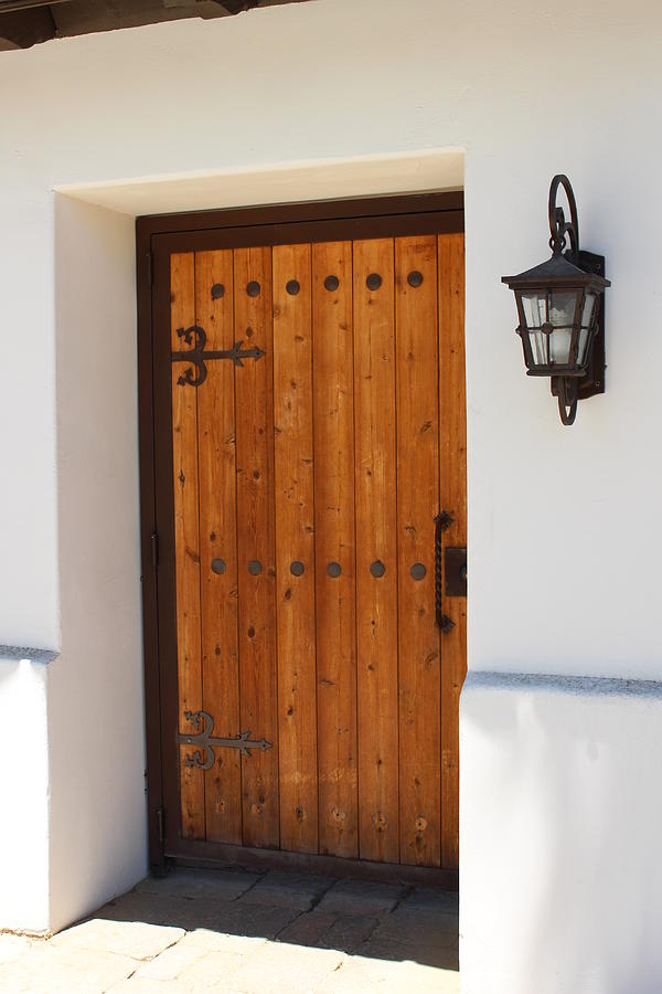 Wooden Door in Stucco Wall with Ornate Outside Lamp Photograph by Colleen Cornelius