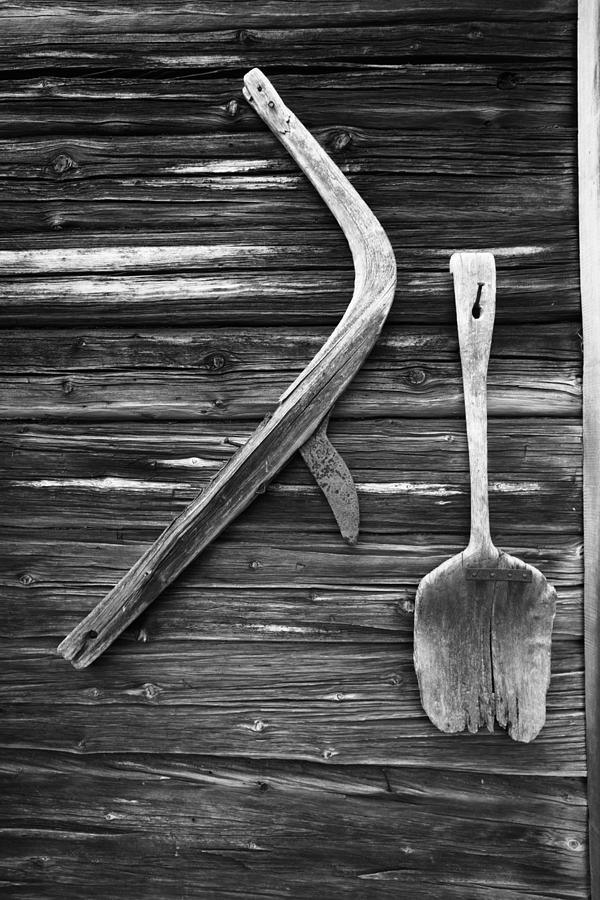 Wooden hand plow and shovel on a log house wall - monochrome Photograph by Ulrich Kunst And Bettina Scheidulin