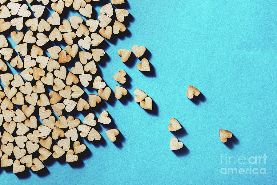 Wooden hearts laying on blue background. Photograph by Michal Bednarek