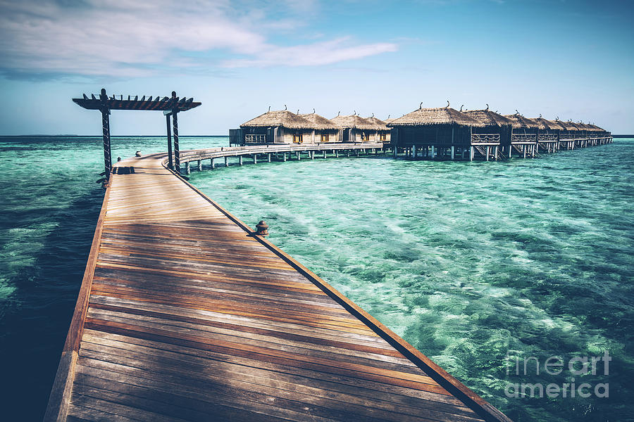 Wooden jetty with arch on a clean turquoise ocean water. Photograph by Michal Bednarek