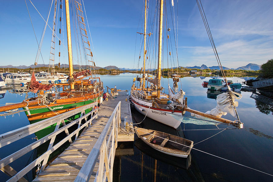 Wooden sailing ships are moored in the small boat harbor in Ringstad in Norway Photograph by Ulrich Kunst And Bettina Scheidulin
