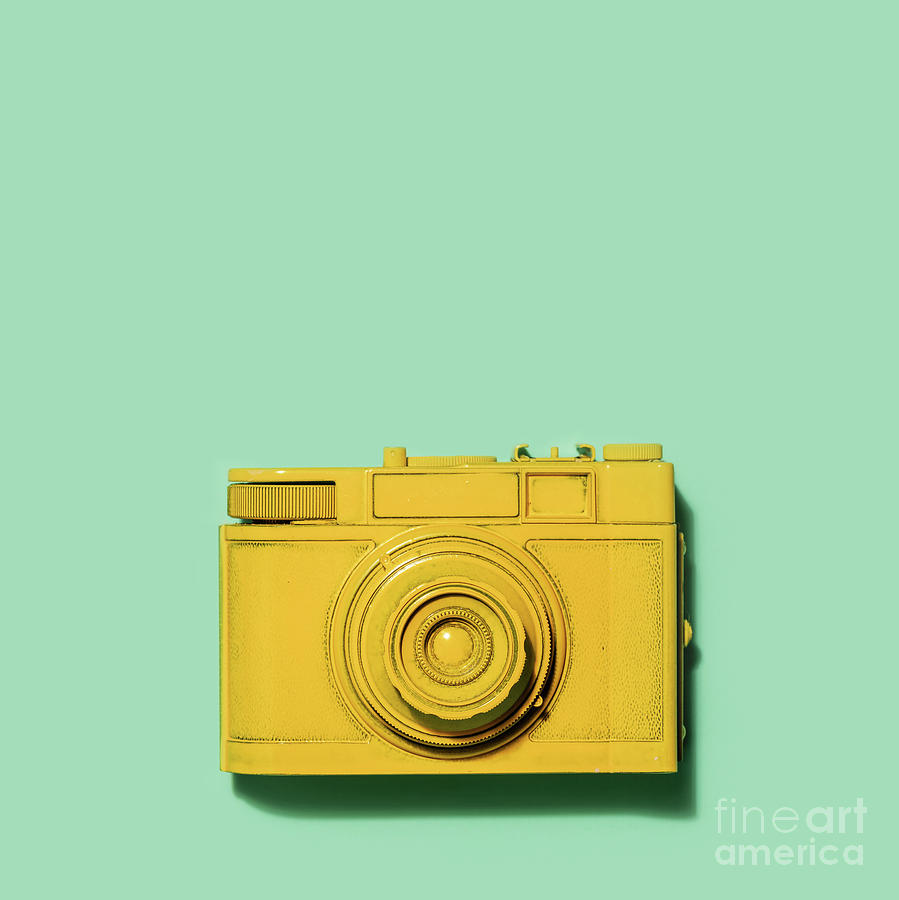 Yellow camera laying on a green background Photograph by Michal Bednarek