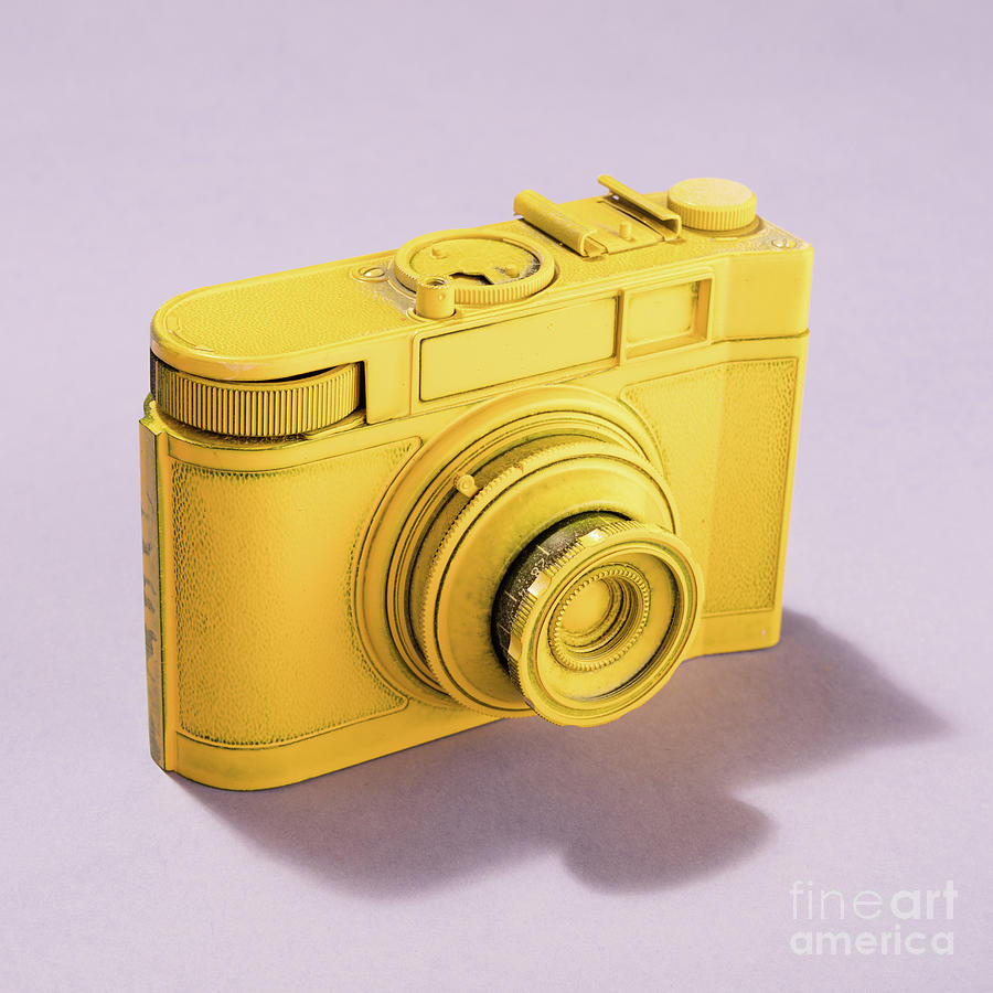 Yellow camera on pastel background. Photograph by Michal Bednarek