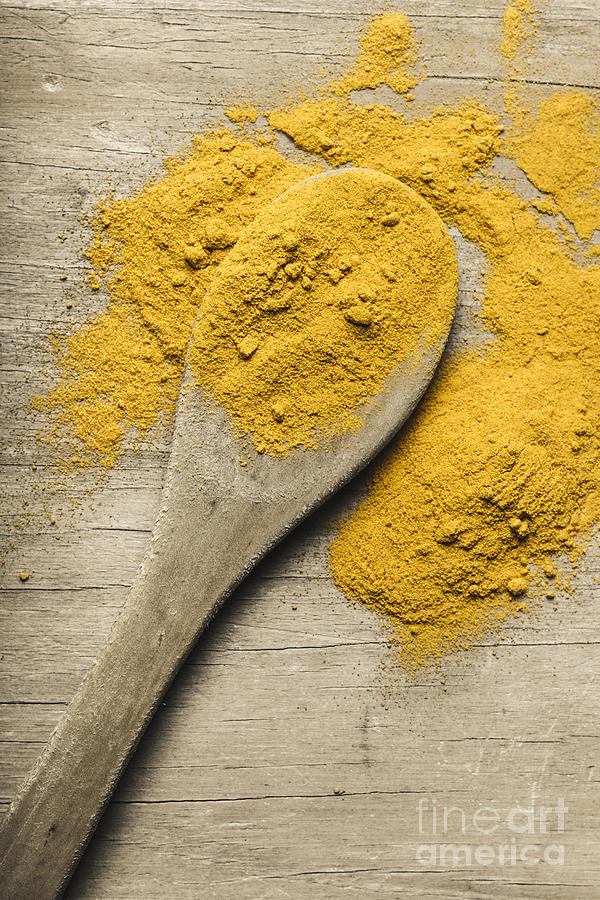 Yellow turmeric spice on wooden serving spoon Photograph by Jorgo Photography