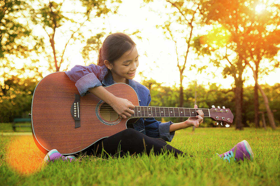 Young artist play solo guitar in green nature park Photograph by Anek Suwannaphoom