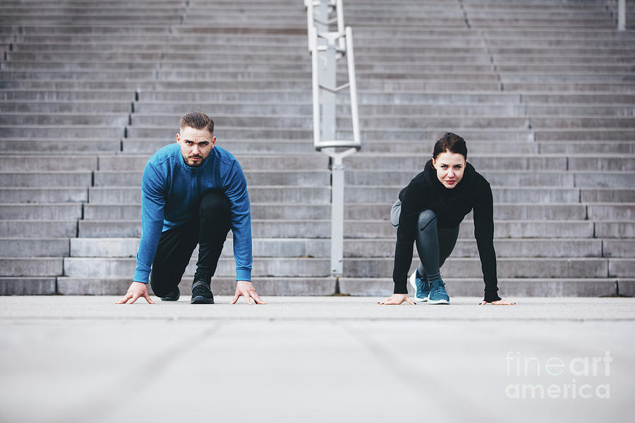 Young athletic couple in a steady position crouching. Photograph by Michal Bednarek