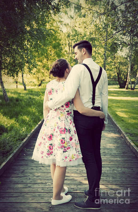 Young couple embrace while standing on wooden path Photograph by Michal Bednarek