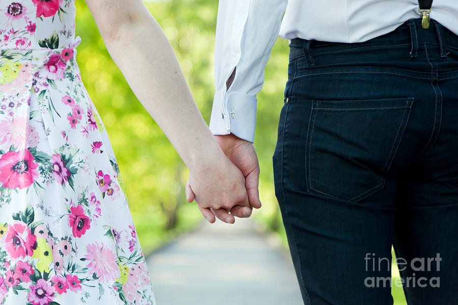 Young couple in love holding hands in summer park Photograph by Michal Bednarek