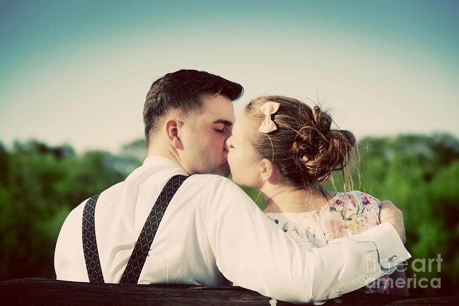 Young couple in love kissing on a bench in park Photograph by Michal Bednarek