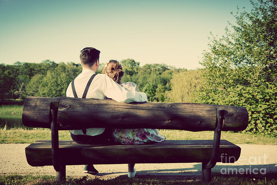 Young couple in love sitting on a bench in park Photograph by Michal Bednarek
