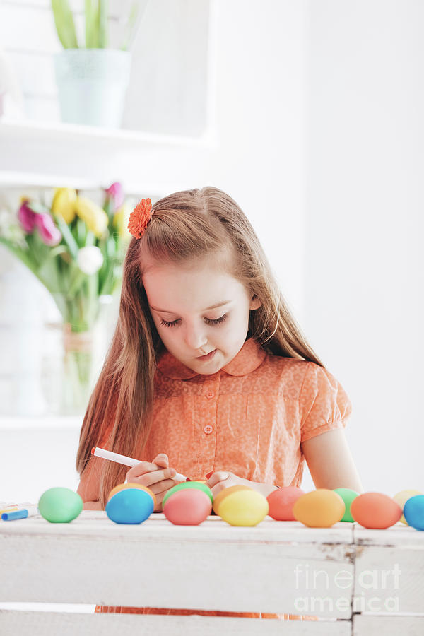 Young focused girl drawing patterns on dyed eggs Photograph by Michal Bednarek