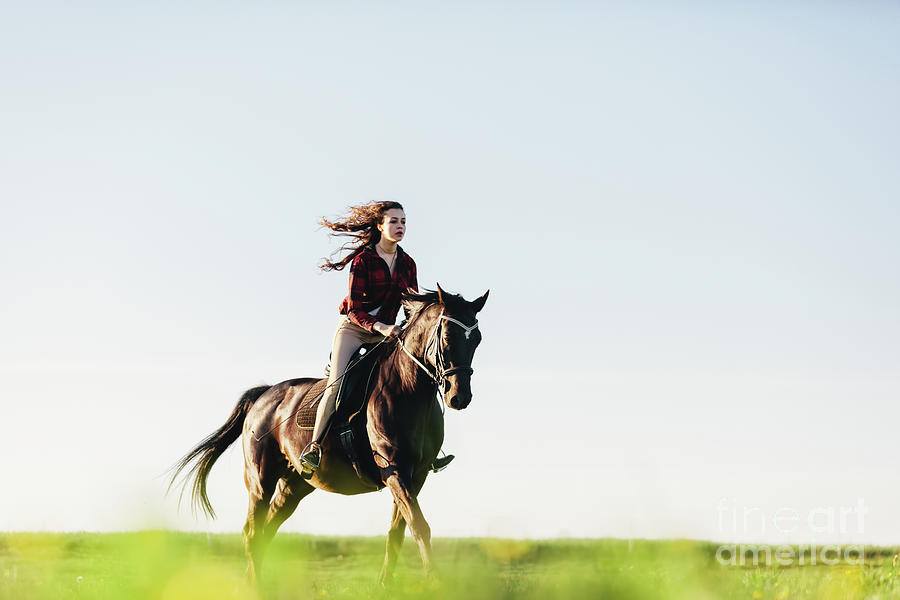Young girl dressed casually riding a horse. Photograph by Michal Bednarek