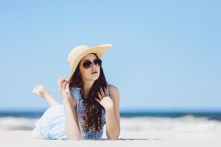 Young girl laying on the beach in a hat and sunglasses Photograph by Michal Bednarek