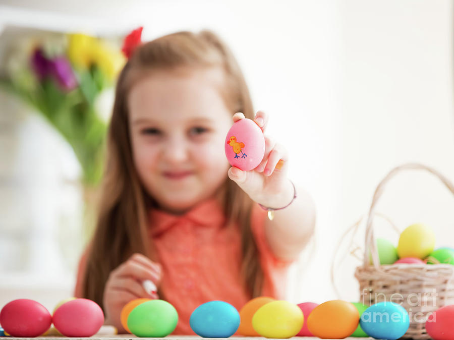 Young girl showing drawing on an egg. Photograph by Michal Bednarek