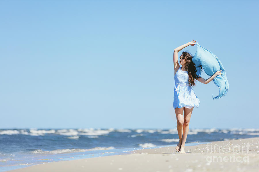 Young girl walking on the beach with blue scarf Photograph by Michal Bednarek