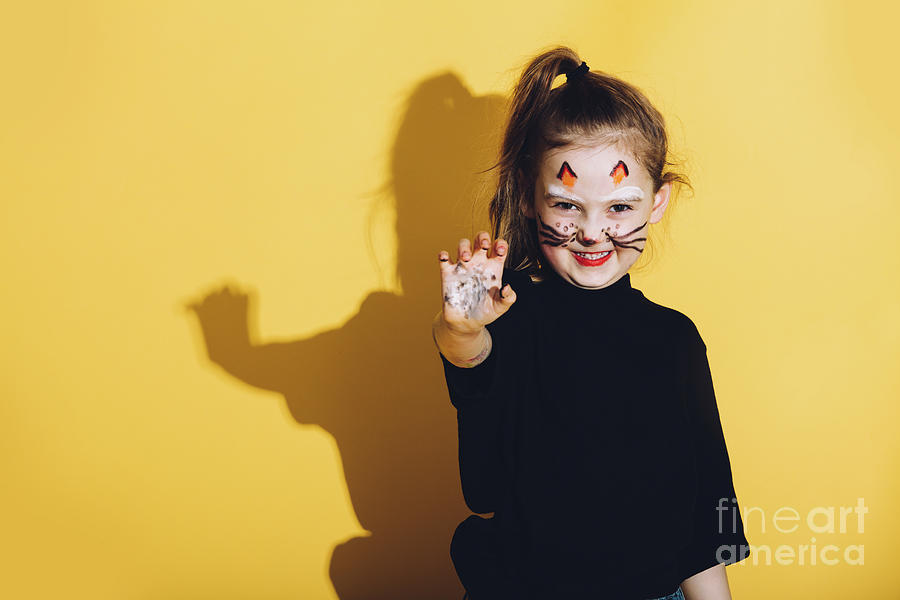 Young girl with cat makeup on her face. Photograph by Michal Bednarek