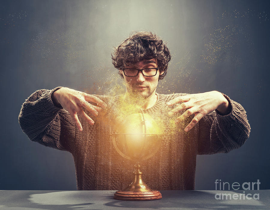Young man gazing at the glowing crystal ball. Photograph by Michal Bednarek