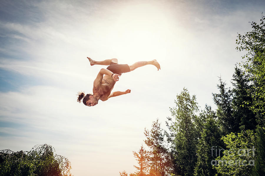Young Man Jumping High In The Sky. Photograph