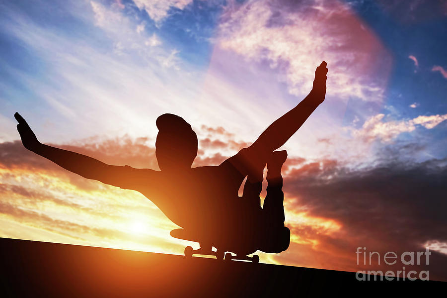 Young man lying on skateboard at sunset. Photograph by Michal Bednarek