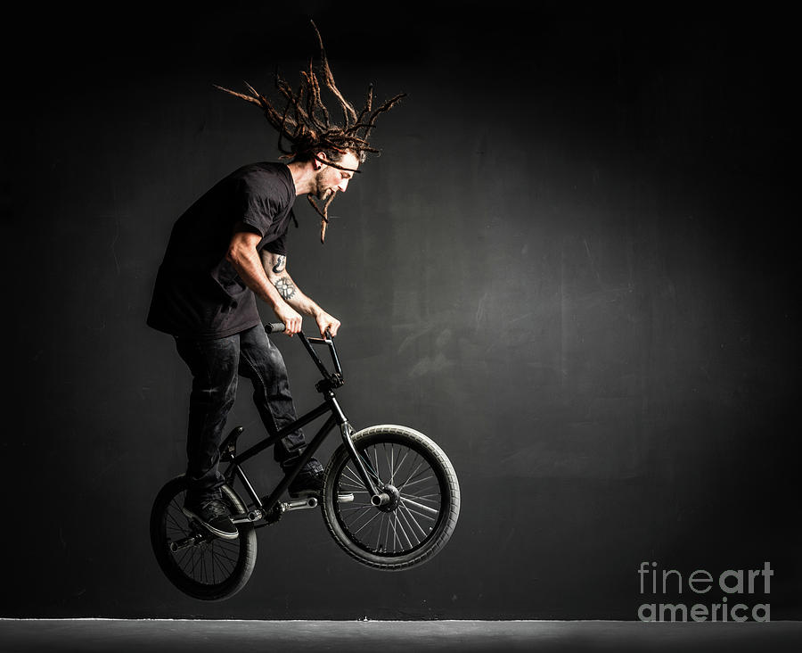 Young sportsman doing stunts on his professional bicycle. Photograph by Michal Bednarek
