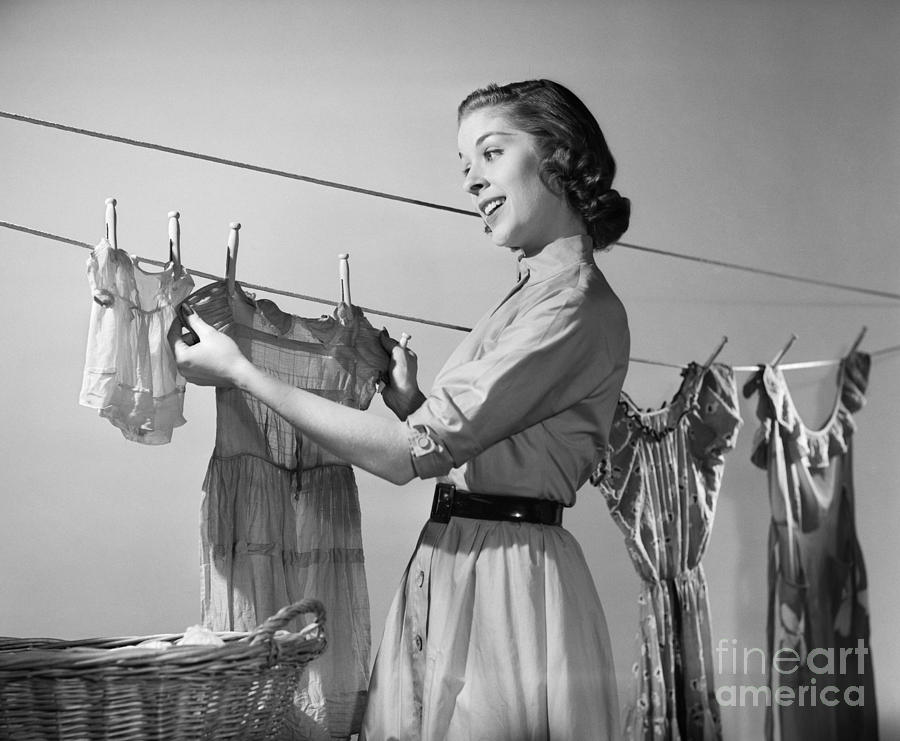 Young Woman Hanging Clothes To Dry Photograph by Debrocke/ClassicStock