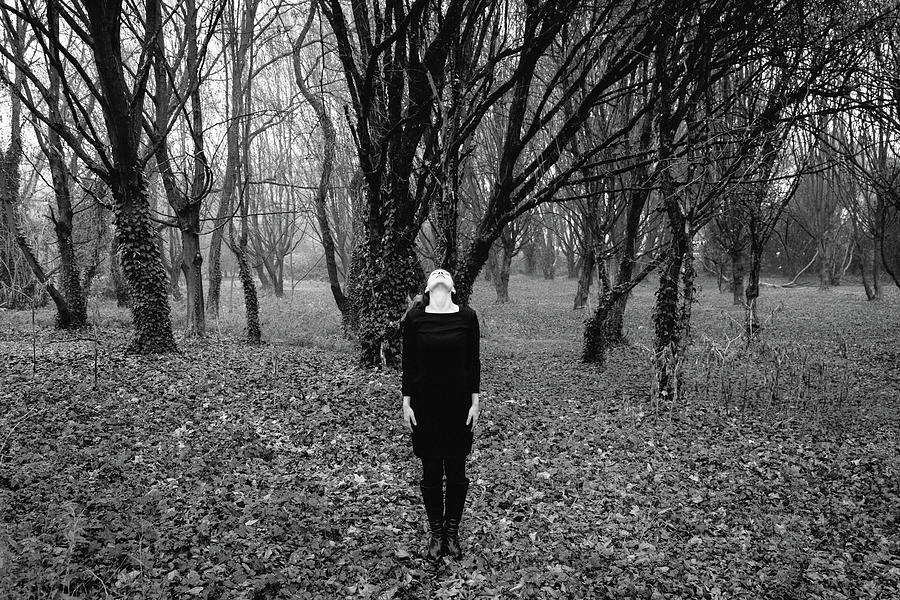 Young woman with her head tilted back while standing in a forest ...