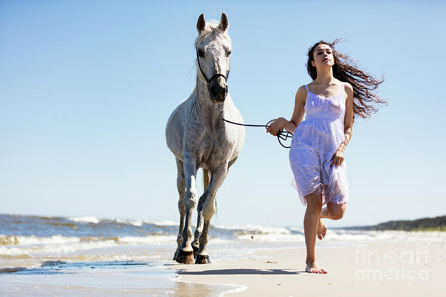 Young woman witth white horse running on the beach Photograph by Michal Bednarek